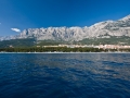 Blick auf den Strand von Makarska vom Meer. Das kristallklare Wasser ist frei von jeglicher Verschmitzung oder Algen.