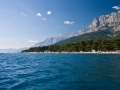Blick auf den Strand von Makarska vom Meer. Das kristallklare Wasser ist frei von jeglicher Verschmitzung oder Algen.