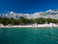 Blick auf den Strand von Makarska vom Meer. Das kristallklare Wasser ist frei von jeglicher Verschmitzung oder Algen.